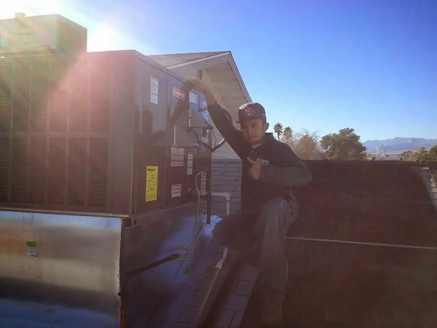 HVAC technician performing Air Duct Repair on a rooftop unit in East Wenatchee